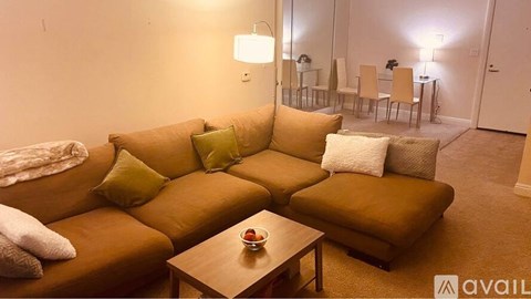 A living room with a brown couch and a coffee table.