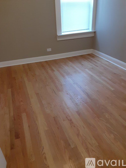 A room with wooden flooring and a window.