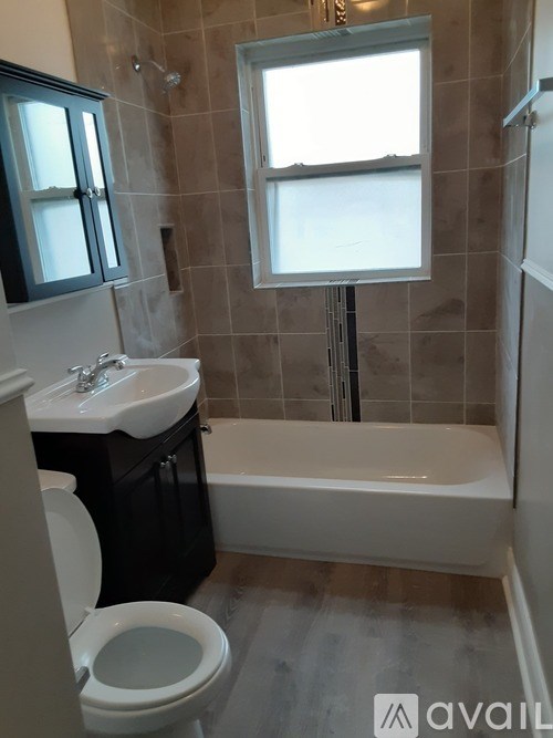 A bathroom with a toilet, sink, and bathtub.