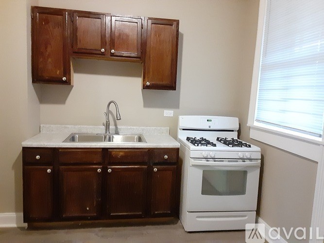 A kitchen with a white stove and wooden cabinets.