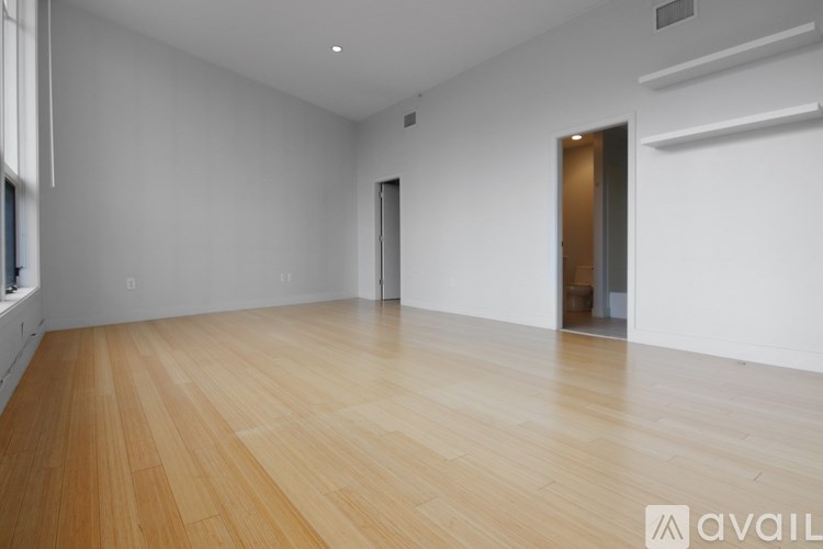 A room with wooden flooring and white walls.