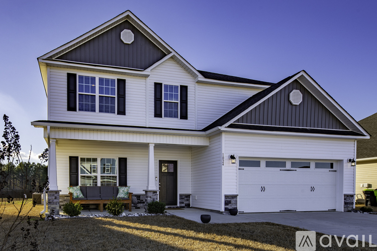A two-story house with a white exterior and black trim.