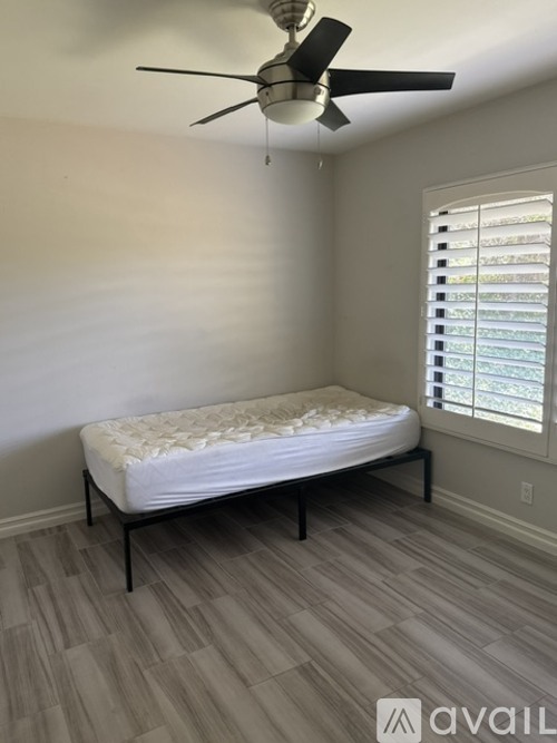 A bedroom with a bed, desk, and chair.
