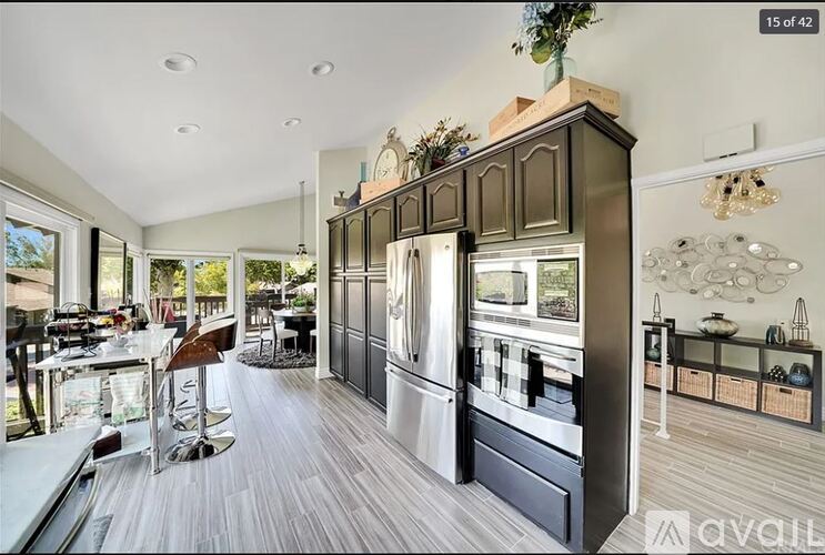 A modern kitchen with dark wood cabinets and a large island.