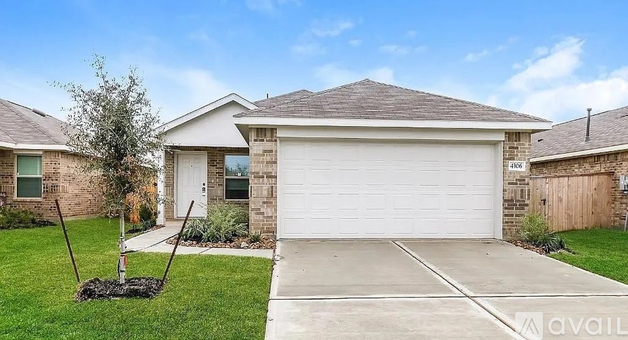 A house with a garage and a driveway in front of it.