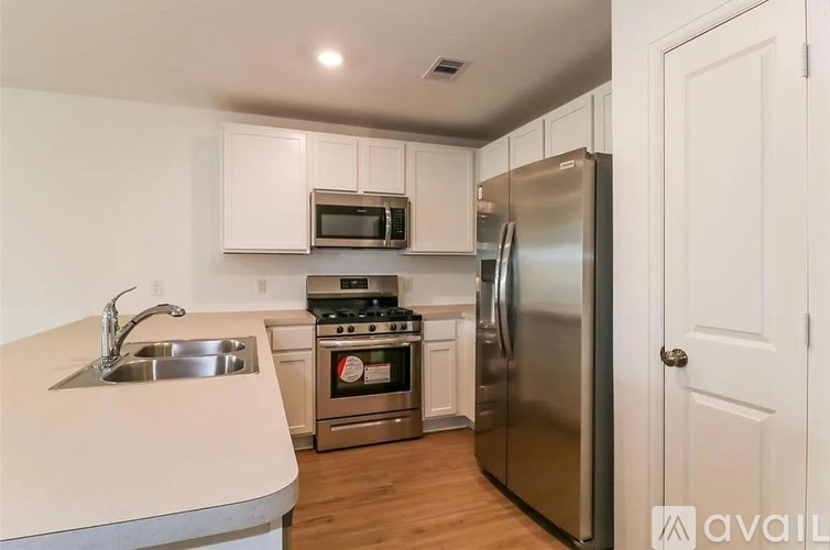 A kitchen with a stainless steel refrigerator, microwave, oven, and sink.