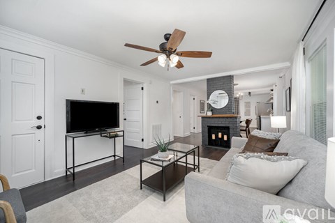 A living room with a grey couch and a fireplace.