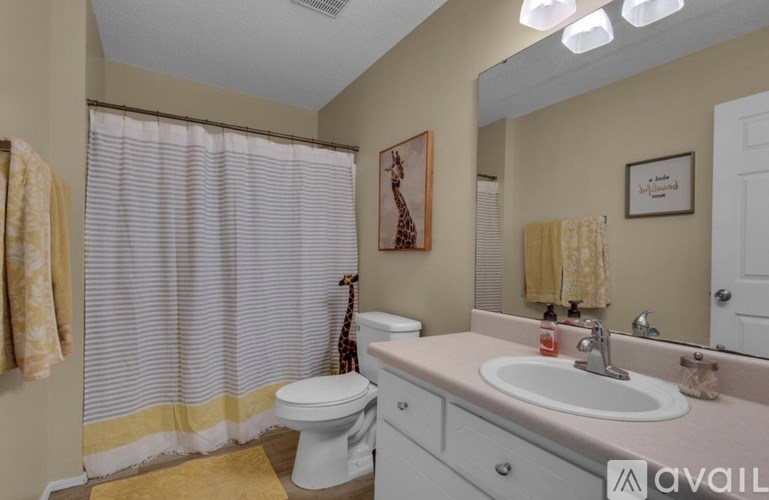 A bathroom with a toilet, sink, and shower curtain.