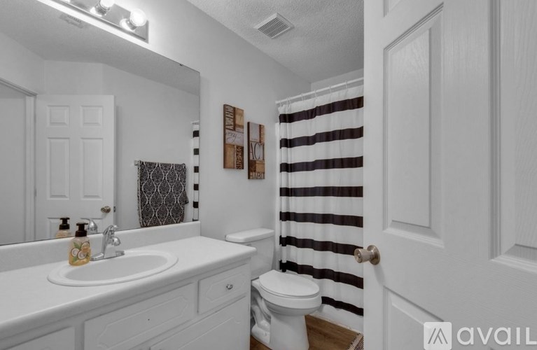 A bathroom with a white sink and toilet.