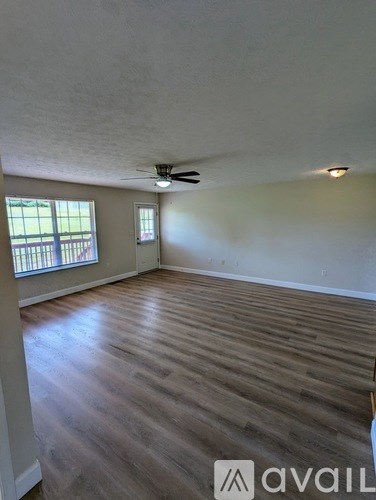 A room with wooden flooring and a ceiling fan.