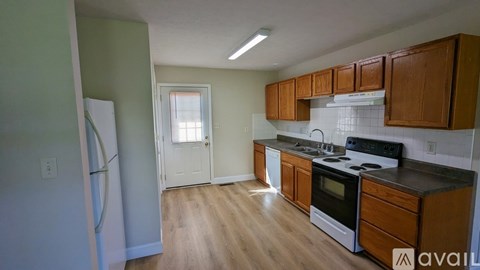 A kitchen with wooden cabinets and a white fridge.