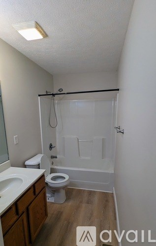 A bathroom with a toilet, sink, and shower.