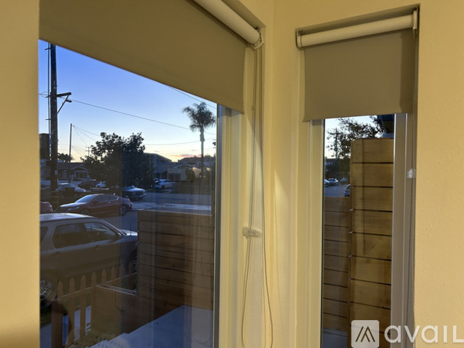 A window with a view of a parking lot and palm trees.