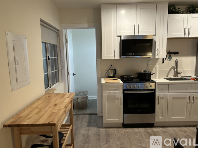 A kitchen with white cabinets and a wooden table.