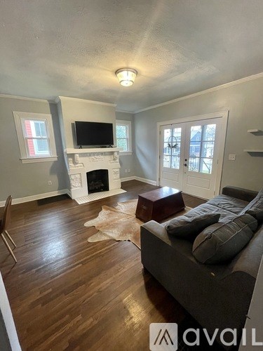 A living room with a grey couch and a fireplace.