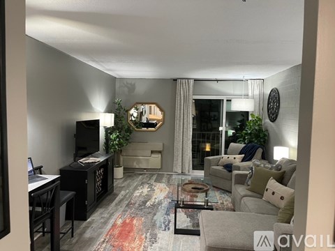 A living room with a grey couch, a black cabinet, a coffee table, and a flat screen TV.