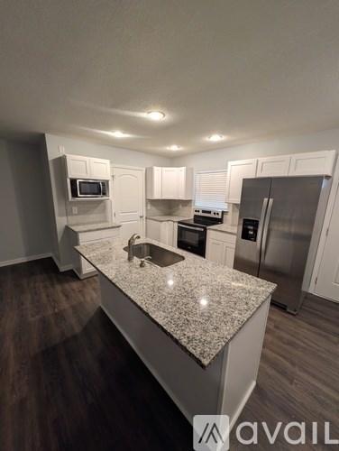 A kitchen with a granite countertop and stainless steel appliances.