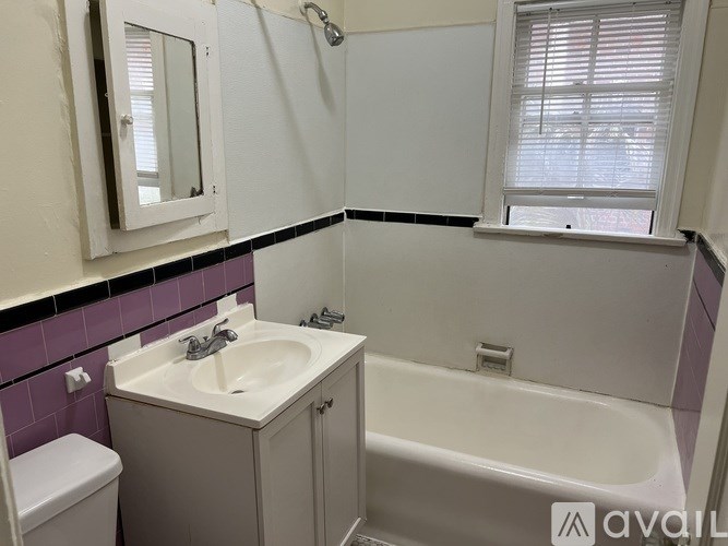 A bathroom with a purple tile wall and a white sink.