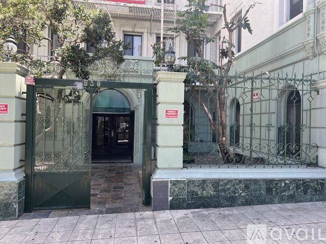 A green and white building with a black door and a red sign on the wall.