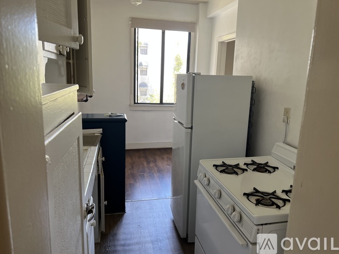 A kitchen with a white fridge, stove and a window.