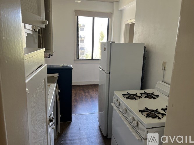 A kitchen with a white fridge, stove and a window.
