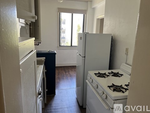 A kitchen with a white fridge, stove and a window.