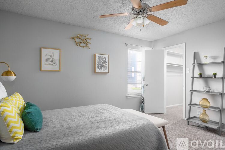 A bedroom with a bed, a ceiling fan, and a window.