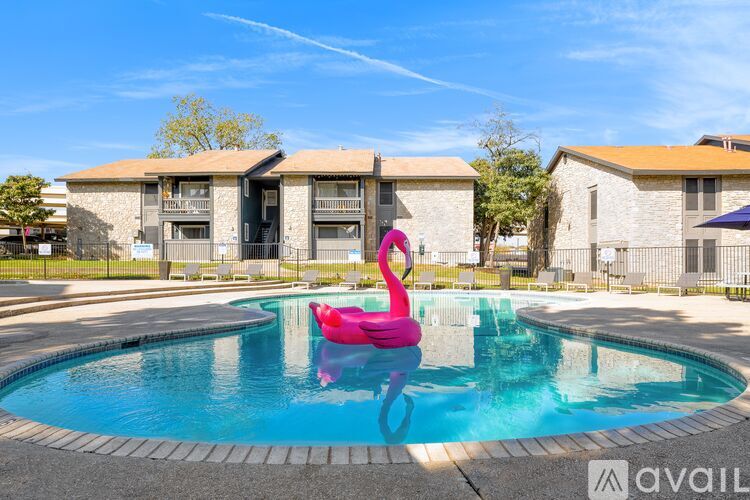 A pool with a pink flamingo float in the middle of it.