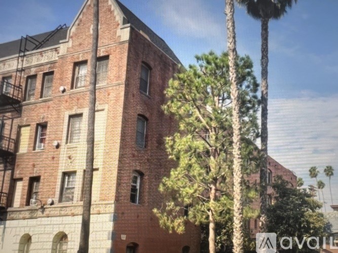 A tall red brick building with a balcony on the second floor.