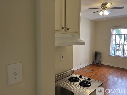 A kitchen with a stove top oven and a window.
