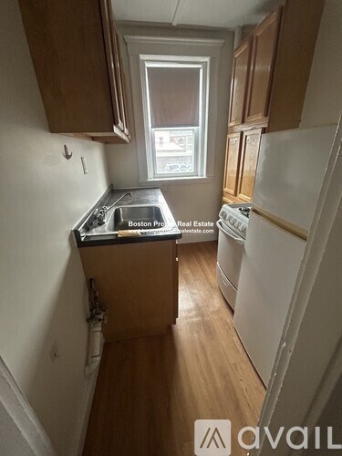 A kitchen with wooden cabinets and a white fridge.