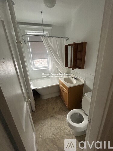 A small bathroom with a toilet, sink, and bathtub.