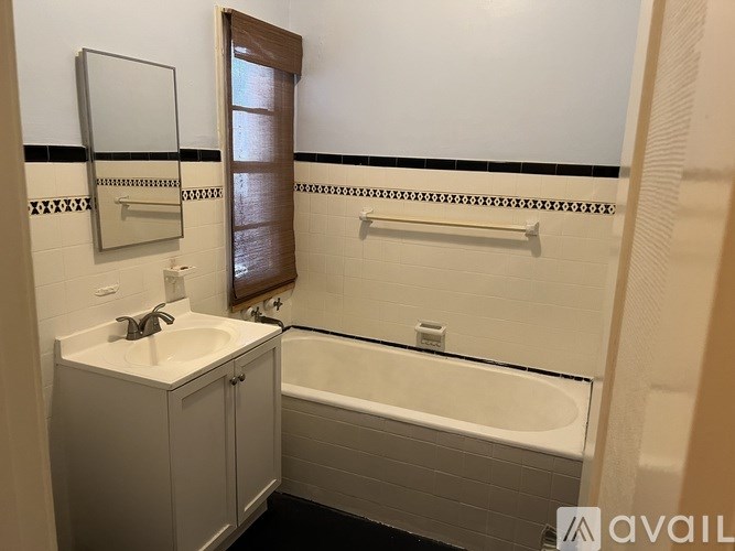 A bathroom with a white tub and sink.