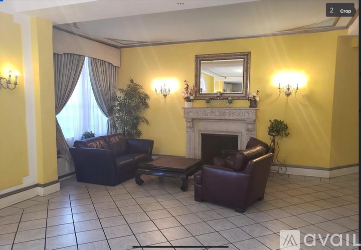 A living room with a fireplace, two chairs, and a mirror.