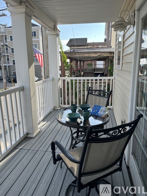 A patio with a table and chairs and an American flag.