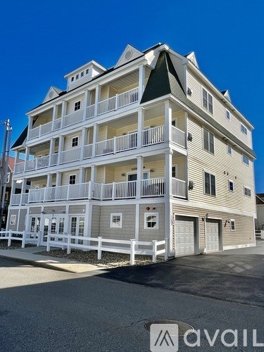 A large white building with a balcony on the second floor.