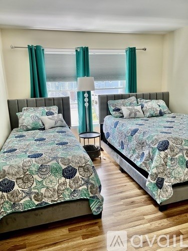 Two beds with green and white bedspreads in a room.