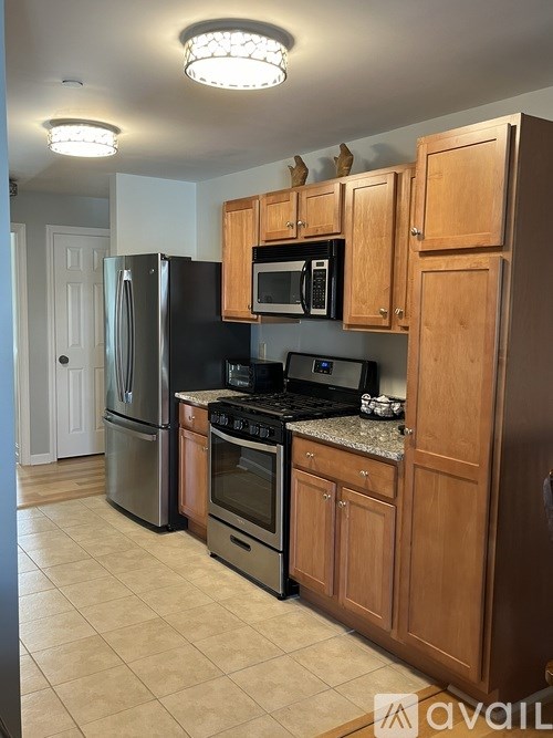 A kitchen with wooden cabinets and black appliances.