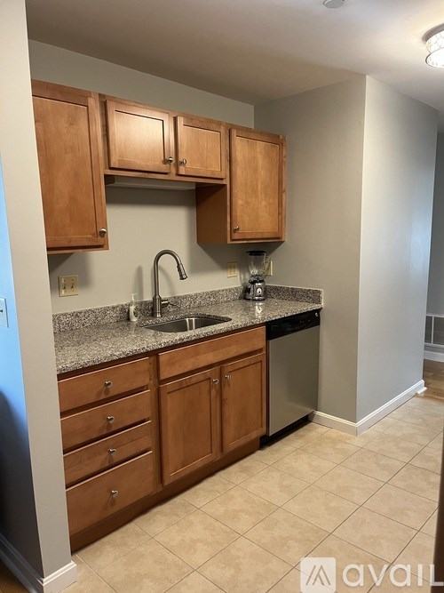 A kitchen with wooden cabinets and a granite countertop.