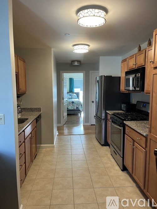 A kitchen with wooden cabinets and black appliances.