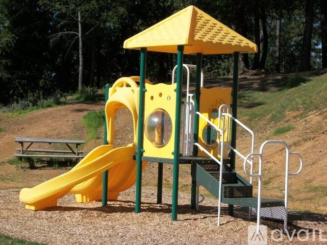 A playground with a yellow slide and a yellow canopy.