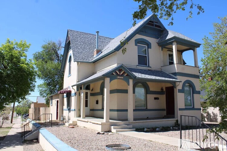 A two-story house with a blue roof and white walls.