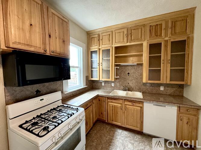 A kitchen with wooden cabinets and a white stove.