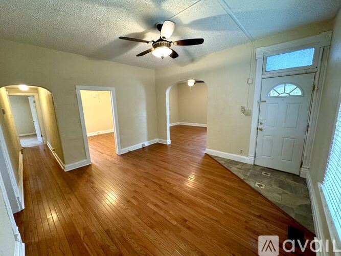 A room with wooden floors and a ceiling fan.