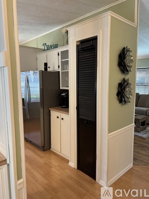 A kitchen with a refrigerator and cabinets.