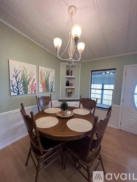 A dining room with a wooden table and chairs.