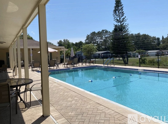 A pool surrounded by a black fence and trees.