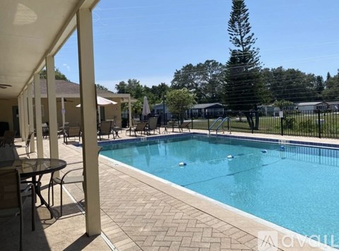 A pool surrounded by a black fence and trees.
