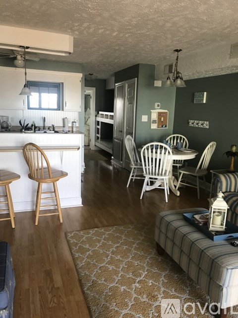 A living room with a grey sofa and a wooden floor.