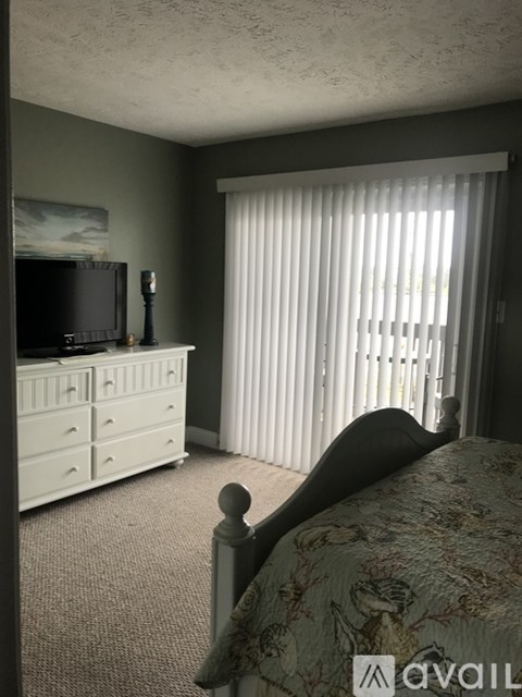A bedroom with a bed, dresser, and television.